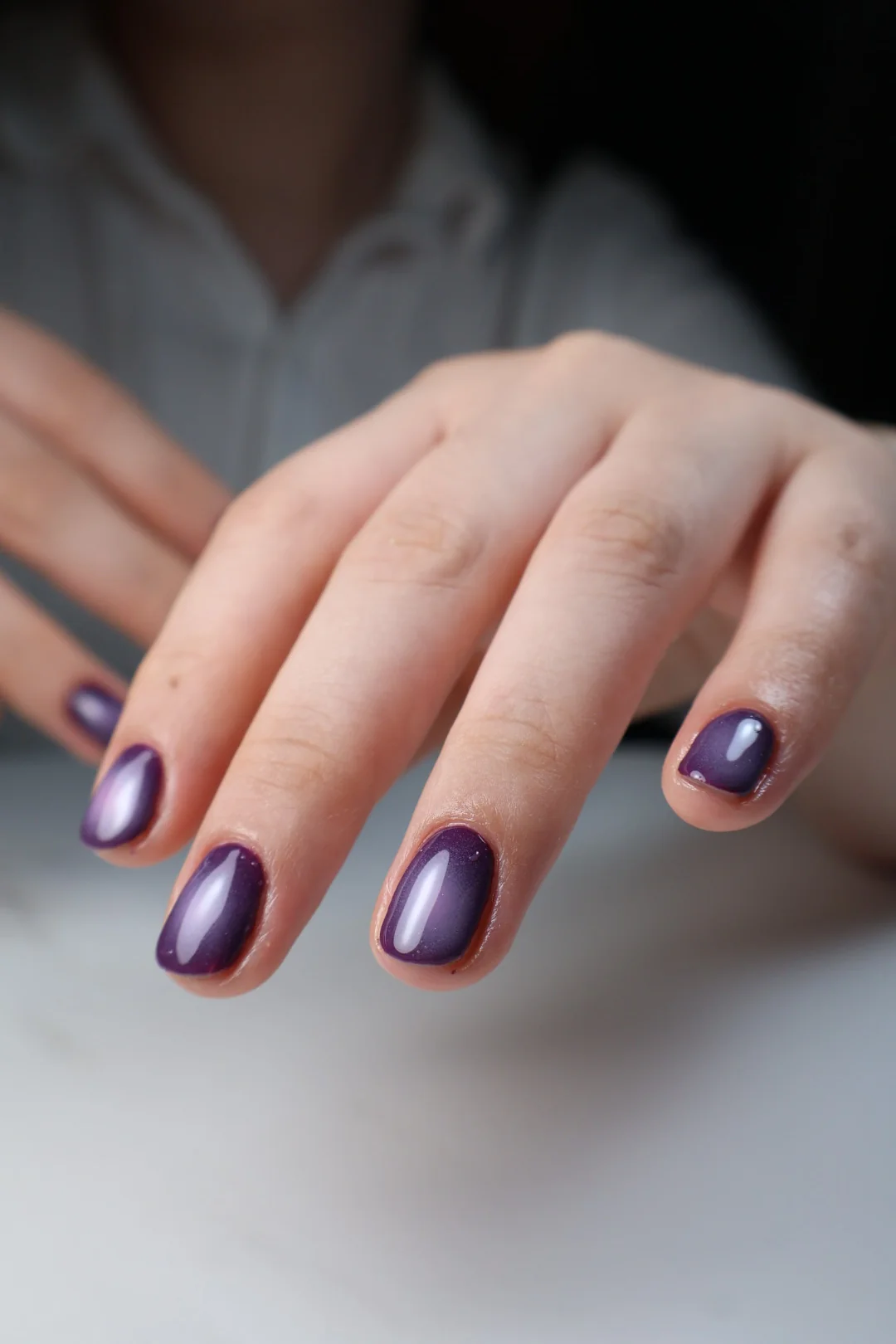 Manicura corta en violeta metalizado.